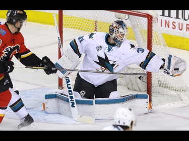 Calgary Flames Michael Ferland tries to get to the puck as it is snagged by San Jose Sharks goalie Martin Jones in NHL hockey action at the Scotiabank Saddledome in Calgary, Alta. on Monday March 7, 2016. Mike Drew/Postmedia