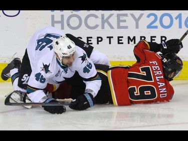 Calgary Flames Michael Ferland is taken down by San Jose Sharks Roman Polak in NHL hockey action at the Scotiabank Saddledome in Calgary, Alta. on Monday March 7, 2016. Mike Drew/Postmedia