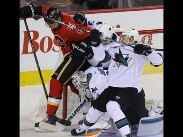 Calgary Flames Joe Colborne  crashes the crease with San Jose Sharks Joonas Donskoi, Matt Nieto and Sharks goalie Martin Jones  in NHL hockey action at the Scotiabank Saddledome in Calgary, Alta. on Monday March 7, 2016. Mike Drew/Postmedia