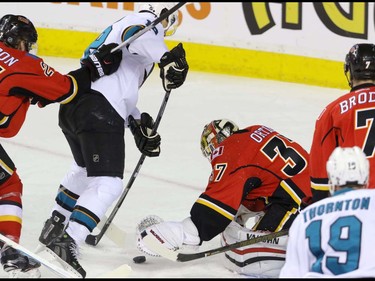 Calgary Flames goalie Joni Ortio jumps on the loose puck as San Jose Sharks Patrick Marleau threatens in NHL hockey action at the Scotiabank Saddledome in Calgary, Alta. on Monday March 7, 2016. Mike Drew/Postmedia