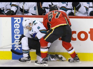 Calgary Flames Michael Frolik rides as San Jose Sharks Joe Pavelski into the boards in NHL hockey action at the Scotiabank Saddledome in Calgary, Alta. on Monday March 7, 2016. Mike Drew/Postmedia