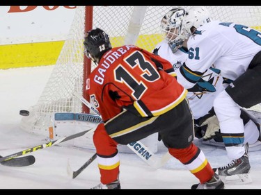 Calgary Flames Johnny Gaudreau heads for the loose puck as San Jose Sharks Justin Braun and goalie Martin Jones move the same way in NHL hockey action at the Scotiabank Saddledome in Calgary, Alta. on Monday March 7, 2016. Mike Drew/Postmedia