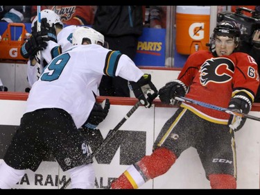 Calgary Flames Michael Frolik  bounces off the boards after a hit by San Jose Sharks Dainius Zubrus in NHL hockey action at the Scotiabank Saddledome in Calgary, Alta. on Monday March 7, 2016. Mike Drew/Postmedia