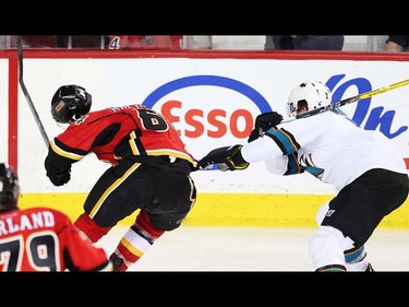 Calgary Flames Garnet Hathaway takes a high stick from Paul Martin of the San Jose Sharks during NHL hockey in Calgary, Alta., on Monday, March 7, 2016. AL CHAREST/POSTMEDIA