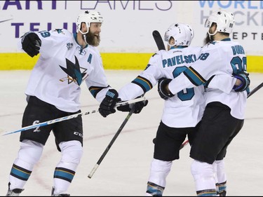San Jose Sharks, left to right, Joe Thornton, Joe Pavelski and Brent Burns celebrate the winning goal in overtime against the Calgary Flames in NHL hockey action at the Scotiabank Saddledome in Calgary, Alta. on Monday March 7, 2016. The Flames lost to the Sharks 2-1 in OT. Mike Drew/Postmedia