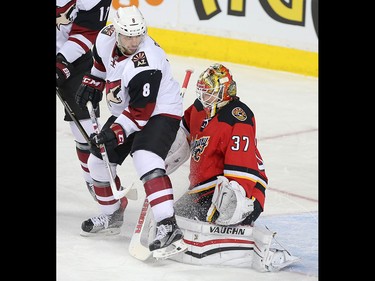 Calgary Flames netminder Joni Ortio, and Arizona Coyotes Tobias Rieder, left, in NHL hockey action at the Scotiabank Saddledome in Calgary, Alta. on Friday March 11, 2016. Leah Hennel/Postmedia