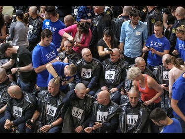 Firefighters and volunteers get their heads shaved as part of the Calgary Fire Department’s Record-Breaking Head Shave, a fundraising event that is attempting to break the Guinness World Record for most heads shaved simultaneously. The current record sits at 267 people. Over 300 people had their heads shaved in the event, unofficially breaking the record as well as raising over $100,000 for cancer research in Calgary, Ab., on Saturday March 12, 2016. Mike Drew/Postmedia