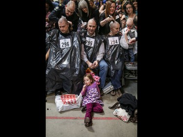 Firefighters and volunteers get their heads shaved as part of the Calgary Fire Department’s Record-Breaking Head Shave, a fundraising event that is attempting to break the Guinness World Record for most heads shaved simultaneously. The current record sits at 267 people. Over 300 people had their heads shaved in the event, unofficially breaking the record as well as raising over $100,000 for cancer research in Calgary, Ab., on Saturday March 12, 2016. Mike Drew/Postmedia