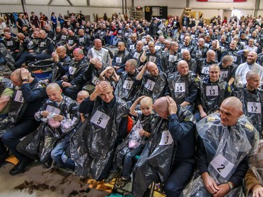 A sea of shiny scalps at the finish of the Calgary Fire Department’s Record-Breaking Head Shave, a fundraising event that is attempting to break the Guinness World Record for most heads shaved simultaneously. The current record sits at 267 people. Over 300 people had their heads shaved in the event, unofficially breaking the record as well as raising over $100,000 for cancer research in Calgary, Ab., on Saturday March 12, 2016. Mike Drew/Postmedia