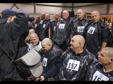 A photographer documents the shaved heads at the finish of the Calgary Fire Department’s Record-Breaking Head Shave, a fundraising event that is attempting to break the Guinness World Record for most heads shaved simultaneously. The current record sits at 267 people. Over 300 people had their heads shaved in the event, unofficially breaking the record as well as raising over $100,000 for cancer research in Calgary, Ab., on Saturday March 12, 2016. Mike Drew/Postmedia