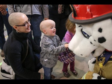 Mom Robin Devine and son Lucas say hi to Sparky, the Calgary Fire Department mascot, after they had their heads shaved as part of the Calgary Fire Department’s Record-Breaking Head Shave, a fundraising event that is attempting to break the Guinness World Record for most heads shaved simultaneously. The current record sits at 267 people. Over 300 people had their heads shaved in the event, unofficially breaking the record as well as raising over $100,000 for cancer research in Calgary, Ab., on Saturday March 12, 2016. Mike Drew/Postmedia