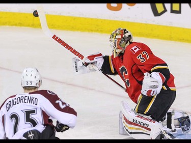 Calgary Flames goalie Joni Ortio bats rebound away as Colorado Avalanche Mikhail Grigorenko threatens in NHL hockey action at the Scotiabank Saddledome in Calgary, Alta. on Friday March 18, 2016. Mike Drew/Postmedia