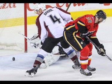 Calgary Flames Matt Stajan redirects a shot past Colorado Avalanche Tyson Barrie and Avalanche goalie Semyon Varlemov in NHL hockey action at the Scotiabank Saddledome in Calgary, Alta. on Friday March 18, 2016. Mike Drew/Postmedia