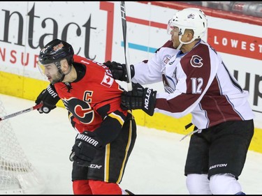 Calgary Flames Mark Giordano battles in the corner with Colorado Avalanche Jerome Iginla in NHL hockey action at the Scotiabank Saddledome in Calgary, Alta. on Friday March 18, 2016. Mike Drew/Postmedia