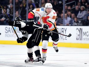 Sam Bennett of the Calgary Flames takes a check from Tanner Pearson of the Kings during the second period at Staples Center in Los Angeles on Thursday night. The Kings won 3-0.