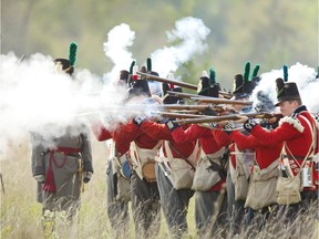 A line of British soldiers fires on the Americans during a re-enactment of the War of 1812.