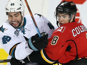 Calgary Flames' Joe Colborne battles against Roman Polak of the San Jose Sharks during NHL hockey in Calgary on Monday.