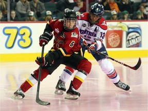 The Calgary Inferno's Rebecca Johnston keeps the puck from the Montreal Stars' Caroline Ouellete in Canadian Women's Hockey League at Scotiabank Saddledome on October 26, 2014.