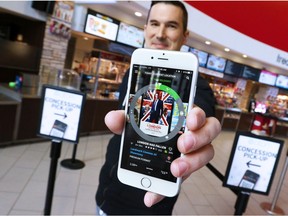 Alex Rouse, Head of Product with Atom Tickets, shows off the company's new app in the Landmark Shawnessy Theatres.