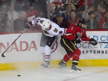 Andrew Ladd and Mark Giordano fight for the puck at the Scotiabank Saddledome in Calgary, Ab, on Saturday, March 26, 2016. The Calgary Flames faced off against the Chicago Blackhawks.