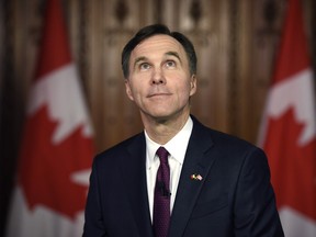 Minister of Finance Bill Morneau looks up in the foyer of parliament as he participates in TV interviews after tabling the federal budget on Parliament Hill in Ottawa on Tuesday, March 22, 2016.
