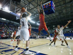 Carleton Ravens' Gavin Resch (3) tries to inbound the ball as Calgary Dinos' David Kapinga (0) defends during CIS men's national university basketball championship final game action in Vancouver, B.C., on Sunday, March 20, 2016