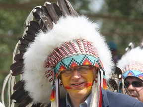 Stephen Harper wears a headdress given to him by the Blood Tribe during a ceremony making him an honorary chief in July 2011.