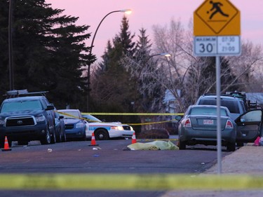The sunrise brightens the sky at a murder scene on the 100 block of Whiteview Road in Whitehorn Tuesday morning. A person was shot in the street at about 3:00 AM.