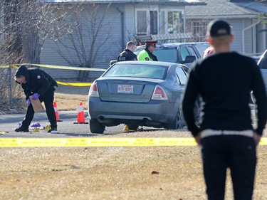 A man who said he was a best friend of the victim watches as police investigate a murder scene on the 100 block of Whiteview Road in Whitehorn Tuesday morning. A person was shot in the street at about 3:00 AM.