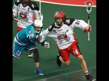 Rochester Knighthawks' Cory Vitarelli tries to slow down the Calgary Roughnecks' Tyson Bell during National Lacrosse League action at the Scotiabank Saddledome in Calgary on Saturday March 5, 2016. Calgary lost 9-8 in overtime.