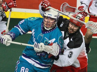The Calgary Roughnecks' Dan MacRae tangles with the Rochester Knighthawks' Cody Jamieson during National Lacrosse League action at the Scotiabank Saddledome in Calgary on Saturday March 5, 2016. Calgary lost 9-8 in overtime.