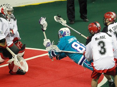 Calgary Roughnecks goaltender Mike Poulin stopes this scoring chance by the Rochester Knighthawks' Codie Jamieson during National Lacrosse League action at the Scotiabank Saddledome in Calgary on Saturday March 5, 2016. Calgary lost 9-8 in overtime.