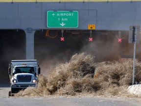 City crews clear out windblown tumbleweeds that blocked access and closed the airport tunnel after strong winds caused damage across the city on Thursday March 10, 2016.