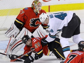 Calgary Flames Deryk Engelland is hauled down in front of Flames goalie Joni Ortio by San Jose Sharks Tomas Hertl in NHL hockey action at the Scotiabank Saddledome in Calgary, Alta. on Monday  night.