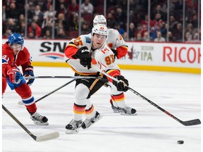 Sam Bennett #93 of the Calgary Flames plays the puck past Paul Byron #41 of the Montreal Canadiens during the NHL game at the Bell Centre on March 20, 2016 in Montreal.