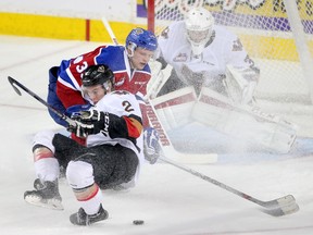 Calgary Hitmen Jake Bean, right and Edmonton Oil Kings Brett Pollock battle for the puck in front  of Hitmen goalie Cody Porter in WHL action at the Scotiabank Saddledome in Calgary, Alberta, on Saturday, March 12, 2016.