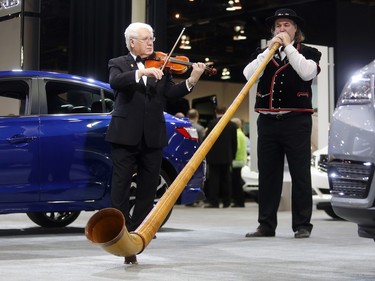 William Hopson of the Calgary Philharmonic plays an alp horn alongside roving violinist Igor Motchalov among the cars and trucks at the Vehicles and Violins Gala Tuesday night March 8, 2016 at the BMO Centre. Sponsored by the Calgary Motor Dealers Association, the gala is in it's 17th year. This year's beneficiaries are Fresh Start Recovery Centre, The Alex and Children's Cottage Society. (Ted Rhodes/Postmedia)