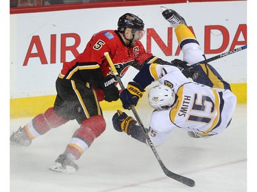 Calgary Flames captain Mark Giordano sends Craig Smith of the Nashville Predators sprawling in the first period at the Saddledome Wednesday March 9, 2016.