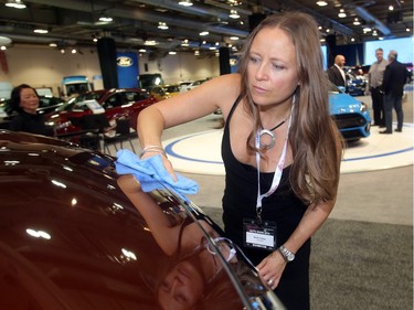 Nicole Tritter buffs up the shine on a Nissan Titan at the Vehicles and Violins Gala Tuesday night March 8, 2016 at the BMO Centre Sponsored by the Calgary Motor Dealers Association, the gala is in it's 17th year. This year's beneficiaries are Fresh Start Recovery Centre, The Alex and Children's Cottage Society. She works with Penske Vehicle Services. (Ted Rhodes/Postmedia)