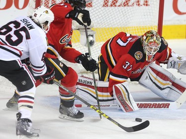 Calgary Flames goalie Joni Ortio turns aside a shot  from Andrew Shaw of the Chicago Black Hawks during the second period at the Saddledome Saturday March 26, 2016.  Also in on the play is Mikael Backlund of the Flames.