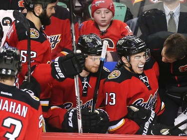 Johnny Gaudreau of the Calgary Flames grimaces on the bench after getting a chop to the hand in the first period against the Chicago Black Hawks at the Saddledome  Saturday March 26, 2016.