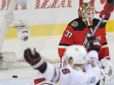 Calgary Flames goalie Joni Ortio sags as Andrew Ladd of the Chicago Black Hawks celebrates a second period Hawks goal at the Saddledome Saturday March 26, 2016.