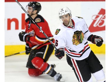 Former Calgary Hitman Andrew Ladd celebrates in front of dejected Calgary Flame TJ Brodie after scoring into an open net during the Chicago Black Hawks 4-1 win at the Saddledome Saturday March 26, 2016.