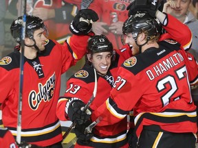 Dougie Hamilton of the Calgary Flames celebrates with Johnny Gaudreau and TJ Brodie after scoring in the second period on the Chicago Black Hawks at the Saddledome Saturday March 26, 2016.