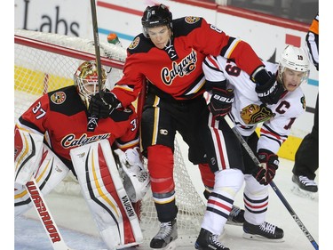 Joe Colborne of the Calgary Flames gets in the face of Chicago Black Hawks captain Jonathan Toews in front of goalie Joni Ortio during the third period of the Hawks 4-1 win at the Saddledome Saturday March 26, 2016.