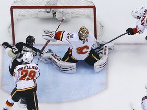 Pittsburgh Penguins' Patric Hornqvist (72) puts the puck behind Calgary Flames goalie Joni Ortio (37) with Deryk Engelland (29) defending for a goal during the first period of an NHL hockey game in Pittsburgh on Saturday.