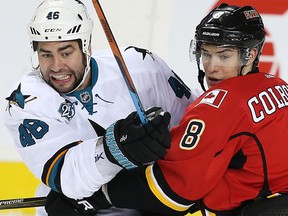 Calgary Flames' Joe Colborne battles against Roman Polak of the San Jose Sharks during NHL hockey in Calgary on Monday, March 7, 2016.