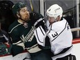 Minnesota Wild's David Jones, left, is penned against the boards by Los Angeles Kings' Brayden McNabb who was called for high sticking on the play in the first period of an NHL hockey game Tuesday, March 22, 2016, in St. Paul, Minn.