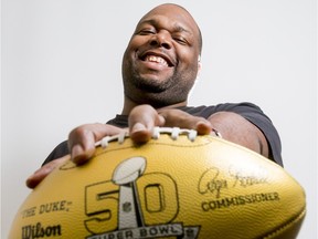 DeVone Claybrooks, the new defensive coordinator for the Calgary Stampeders, mugs for a photo with a golden Super Bowl 50 football inside his office in Calgary, Alta., on Wednesday, March 23, 2016. Claybrooks, a former NFL player, was given the ball during the last Super Bowl. Lyle Aspinall/Postmedia Network