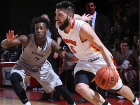 Dinos #5 Jasdeep Gill drives to the basket as #7  Malik Irwin of the Manitoba Bisons defends during Canada West Final Four at Jack Simpson Gym Friday night.